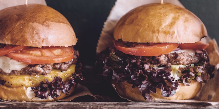 To burgere med skinnende briochebrød og saftige hamburgere av kjøttdeig.